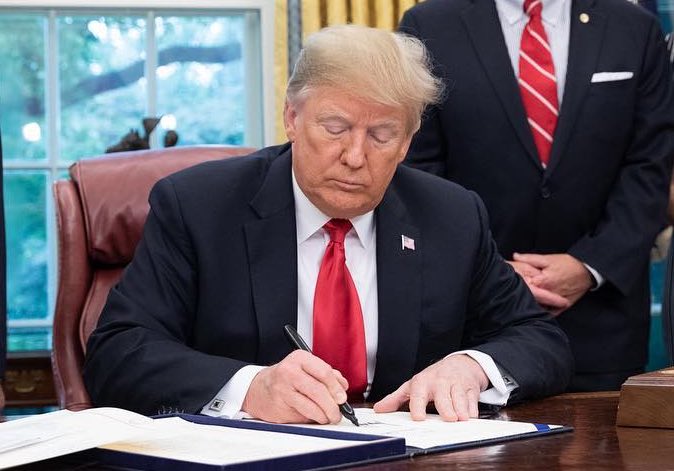 Trump-signing-red-tie.jpg