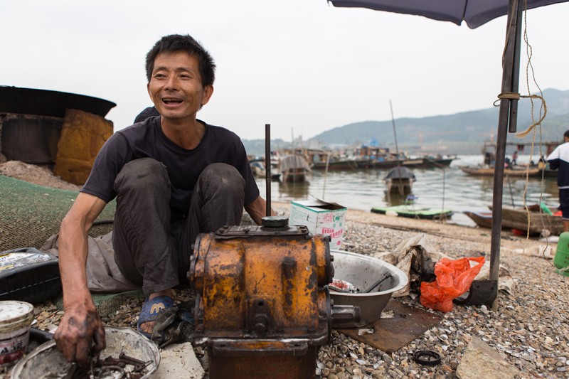 Young-Lin-cleans-his-engine-near-his-boat-in-Datang.jpg
