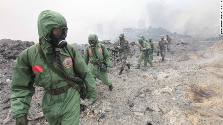 Rescuers in hazmat suits survey the site in Tianjin